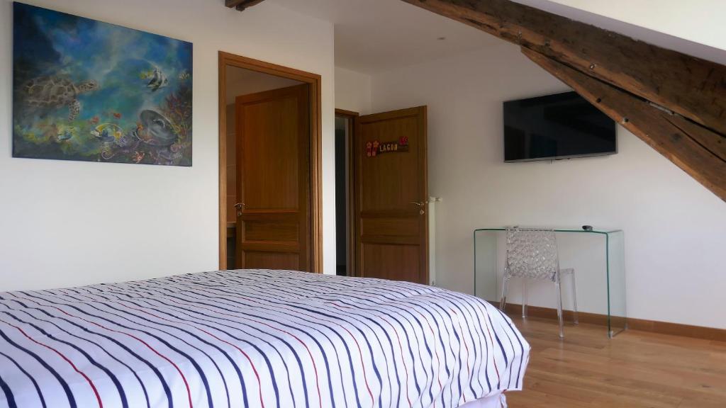 a bedroom with a bed and a tv on the wall at B&amp;B Château de Preuil in Vallenay