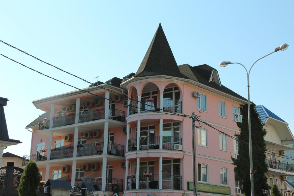 a pink building with a pointed roof at Гостевой дом Райское Местечко in Lazarevskoye