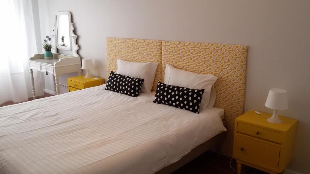 カルカヴェロスにあるCarcavelos Beachのベッドルーム(白い大型ベッド、黒い枕付)