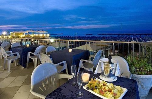 una mesa con un plato de comida en el balcón en Hotel Caravelle, en Cattolica