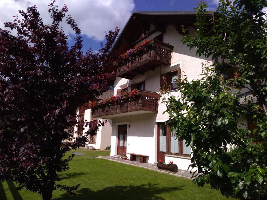 un edificio blanco con balcones y flores. en Casa dello Sciatore, en Bormio