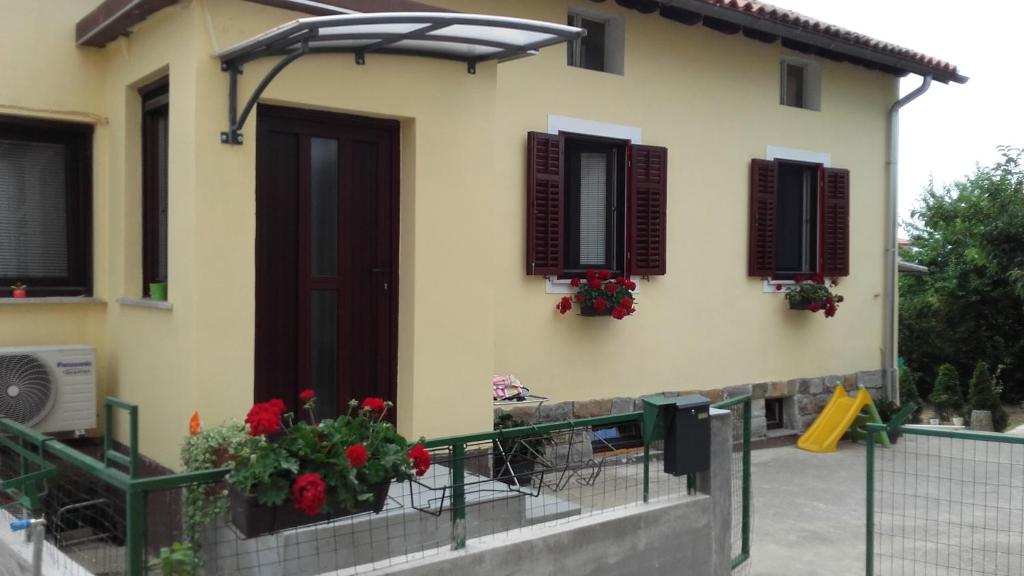 una casa con un balcón con flores rojas. en Apartma_Samy en Izola