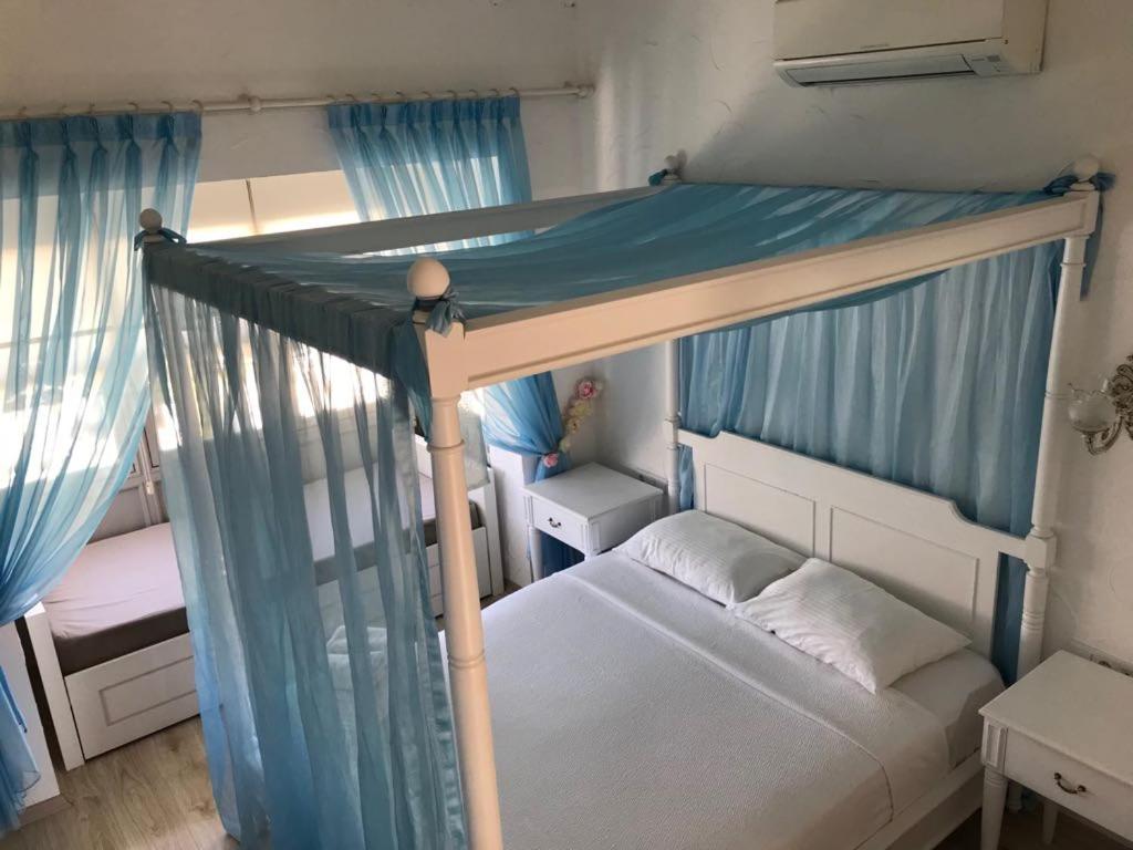 1 dormitorio con litera y cortinas azules en Alacati Alaris Hotel en Alacati