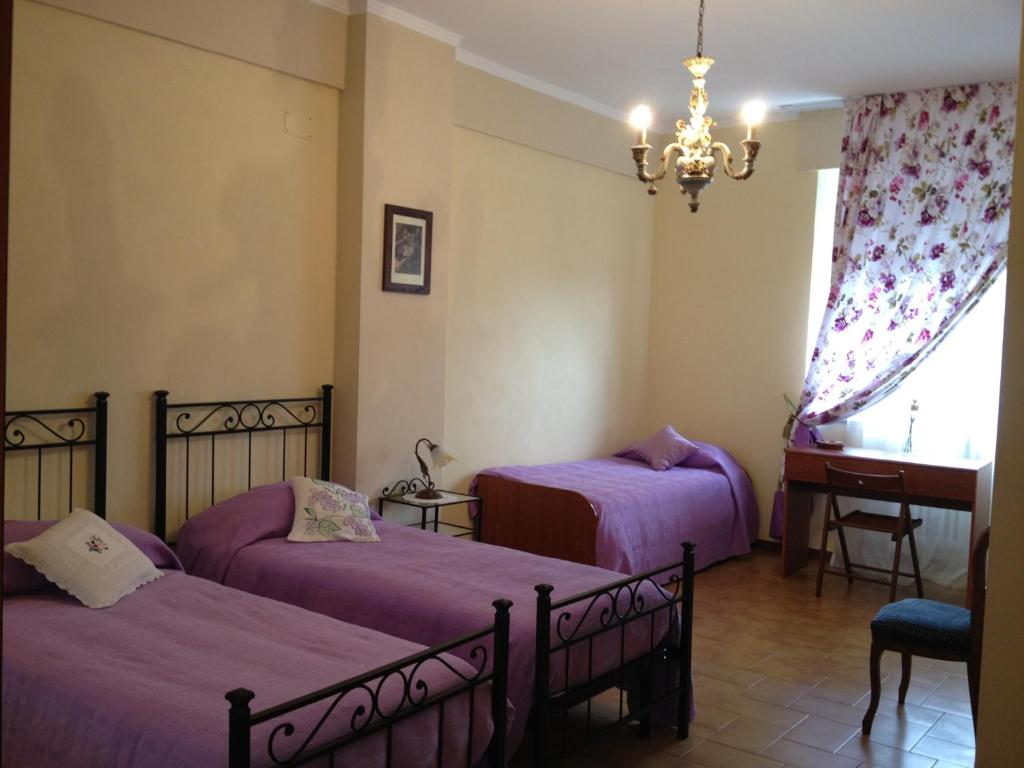 a bedroom with two beds and a chandelier at Vacanze Senesi in Siena