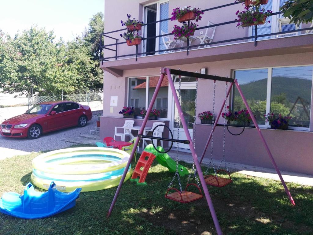 un parque infantil en el patio de una casa en Apartment Beha, en Bihać