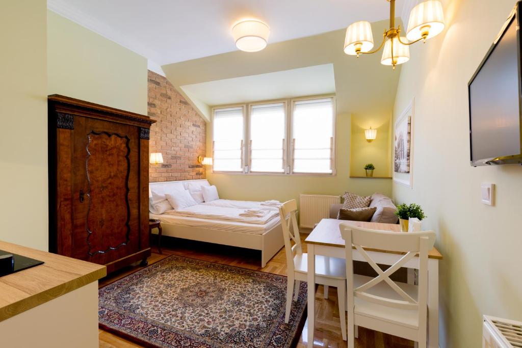 ein kleines Wohnzimmer mit einem Bett und einem Tisch in der Unterkunft Roland Apartments in Budapest