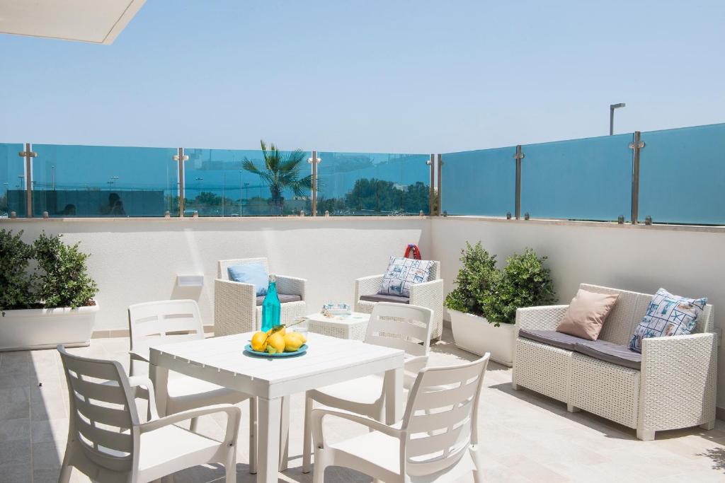 patio con mesa y sillas en el balcón en Apulianstay-Hellen House, en Monopoli
