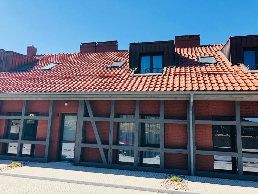 a red brick building with a red roof at Memel home old city apartment in Klaipėda