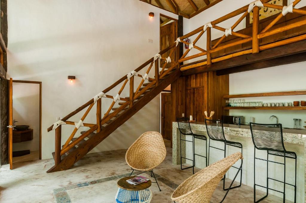 una escalera en una habitación con sillas y un bar en Jungle Chic Villa in Chemuyil, en Tulum