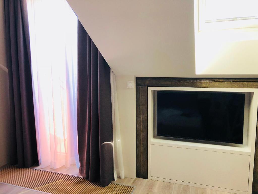 a living room with a flat screen tv next to a window at Memel home old city apartment in Klaipėda
