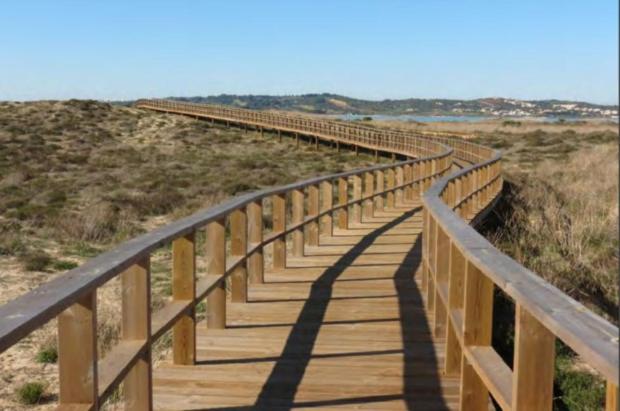 a wooden boardwalk in the middle of a beach at Ria Sunset House Alvor in Alvor