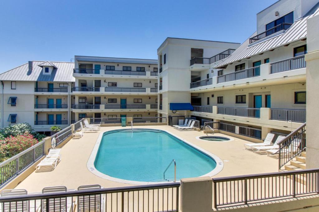 a balcony with a swimming pool in front of a building at The Club at Mexico Beach in Mexico Beach