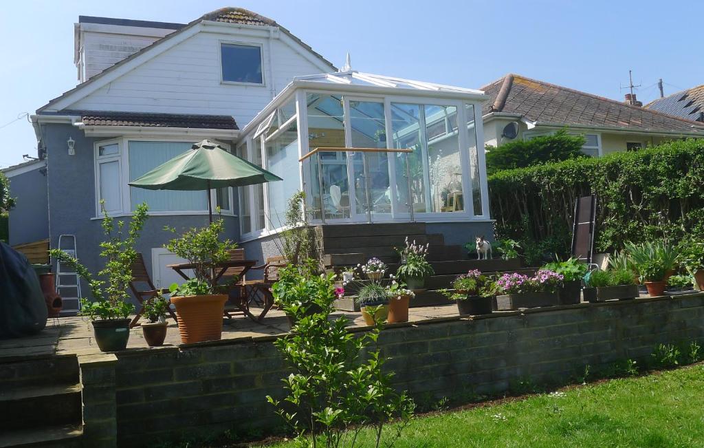 a house with a patio with plants and an umbrella at Sunrise in Newhaven