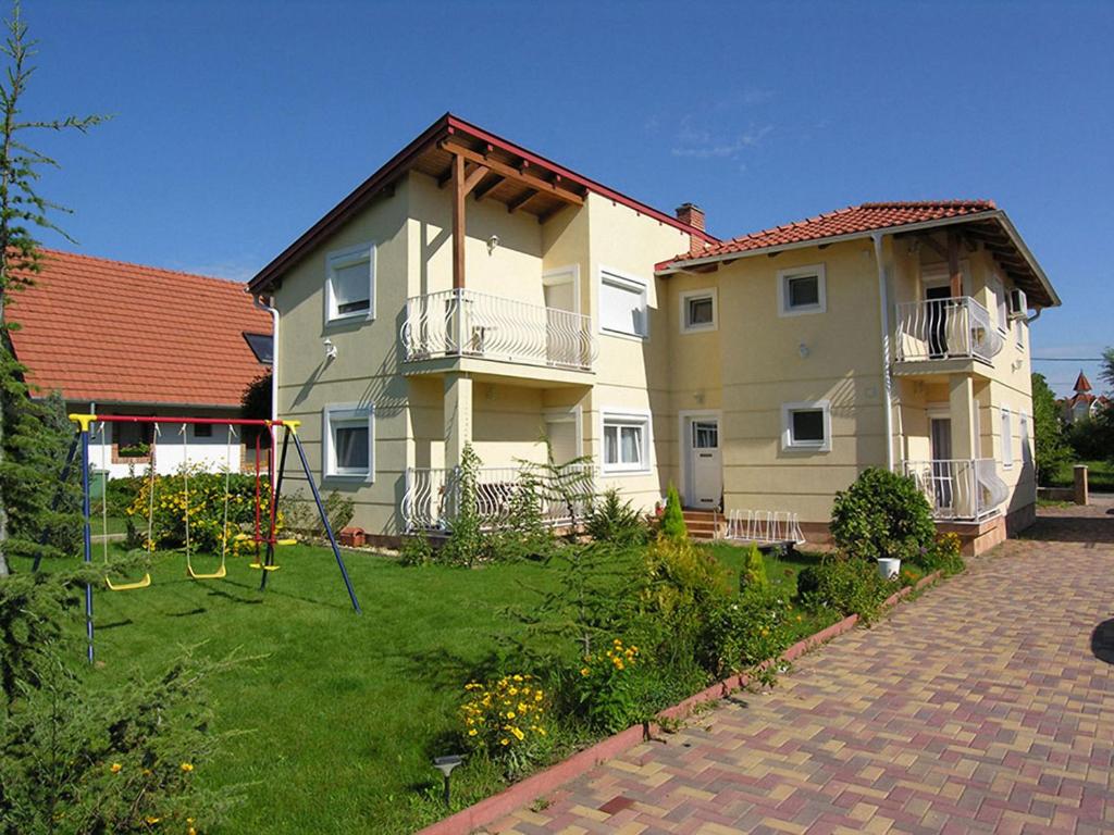 a house with a playground in front of a yard at M&aacute;ria-lak Zalakaros in Zalakaros