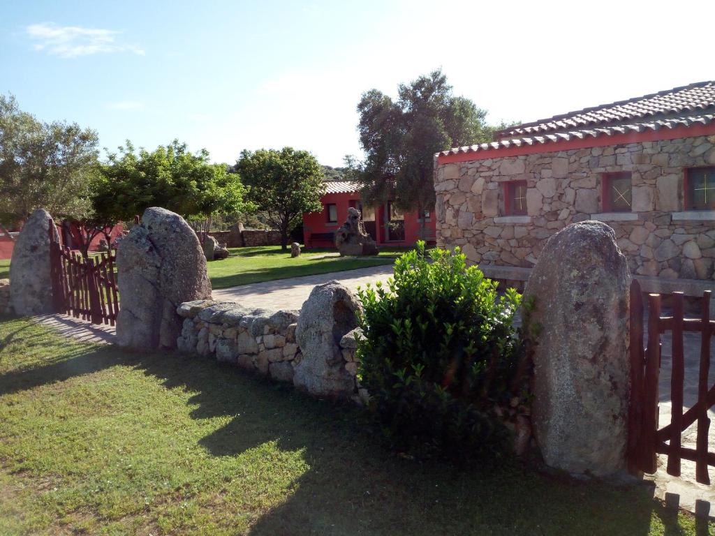 a stone fence with a bunch ofestones in front of a building at Turismo rurale l'Agliuledda in Sant Antonio Di Gallura