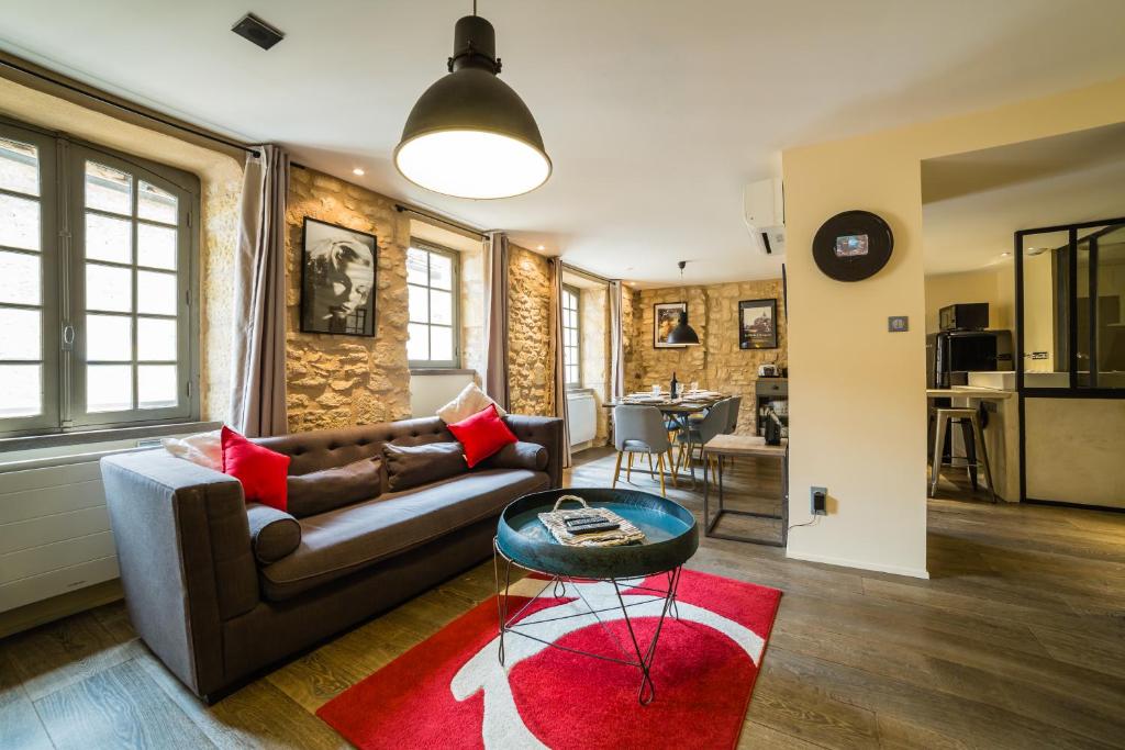 a living room with a couch and a red rug at Le Grand Duplex de Rafael in Sarlat-la-Canéda