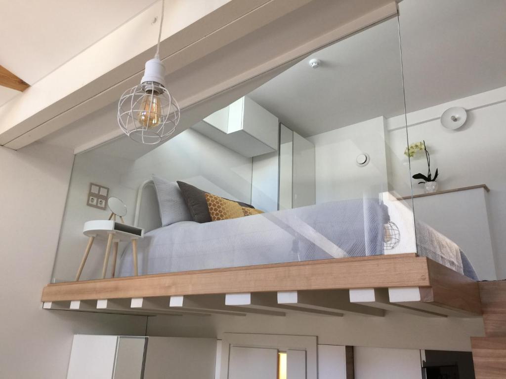 a bedroom with a bed in a mirror at Jolie Apartments in Kaunas