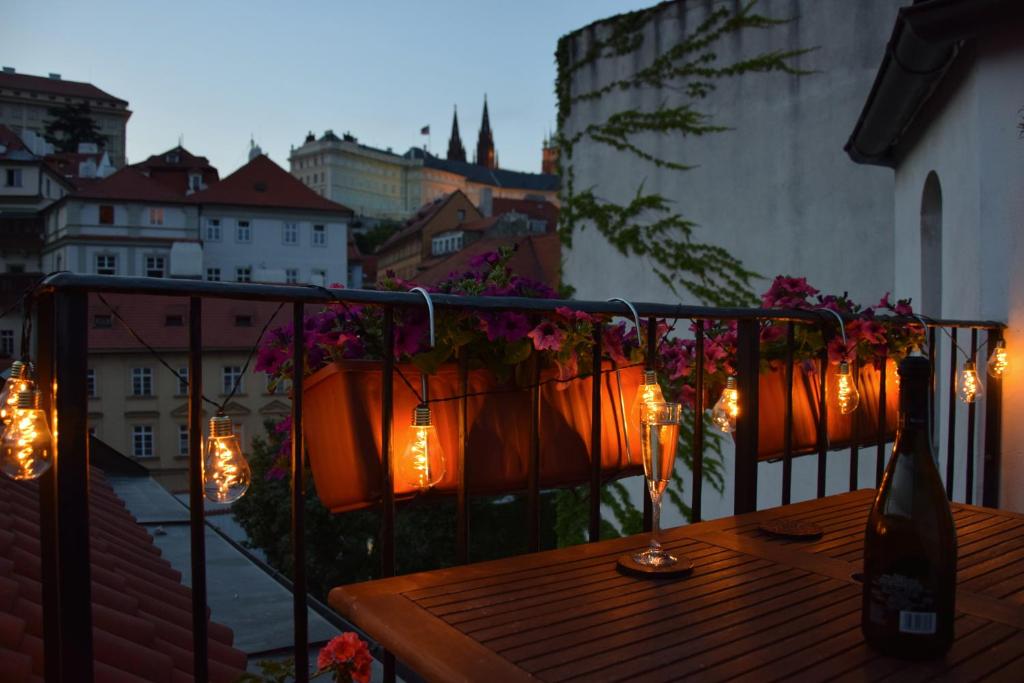una mesa de madera en un balcón con luces. en Apartman Mala Strana en Praga
