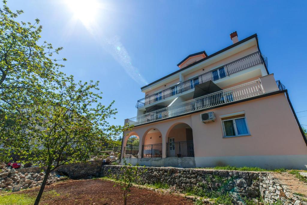 a large white building with a stone wall at Apartments Raspolic in Kastav
