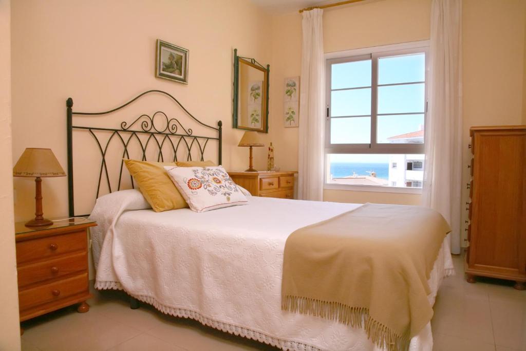 ein Schlafzimmer mit einem großen Bett und einem Fenster in der Unterkunft Apartamento Con Vistas en Nerja in Nerja