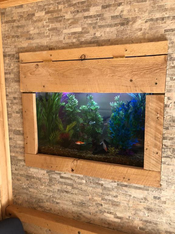 a fish tank in a wooden box on a brick wall at Villa Marie in East Durham