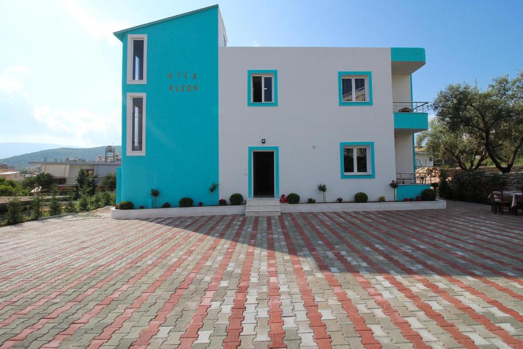 a blue and white house with a brick patio at Vila Kleon in Ksamil