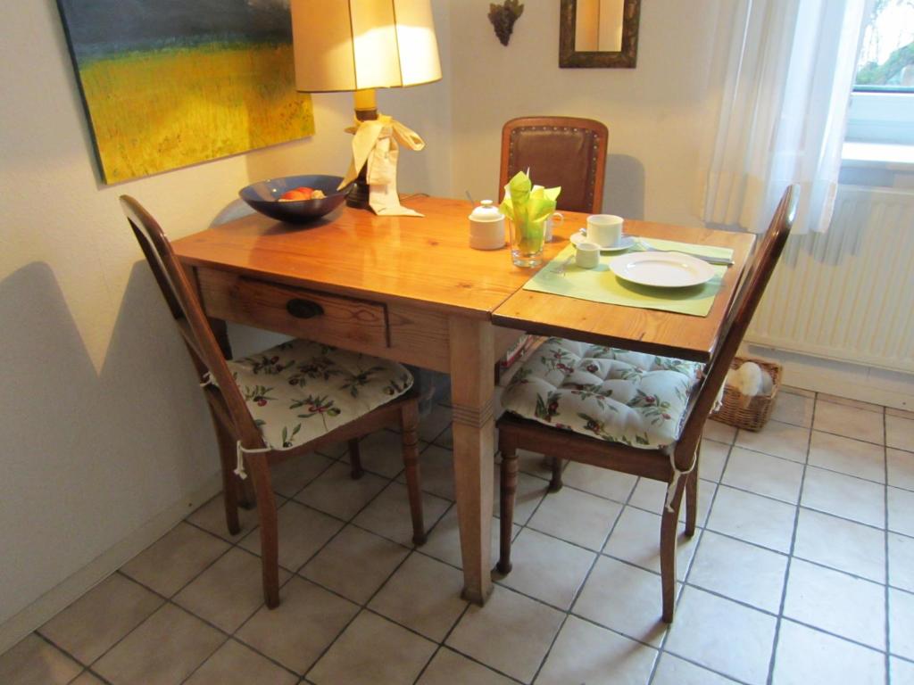 ハノーファーにあるPrivate Room with Breakfastの木製テーブル(椅子2脚、ランプ付)