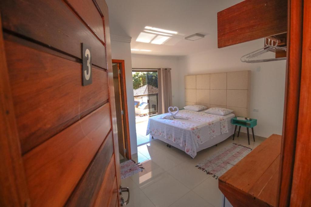 a bedroom with a bed and a sliding door at Pousada Bonito Cama e Café in Bonito