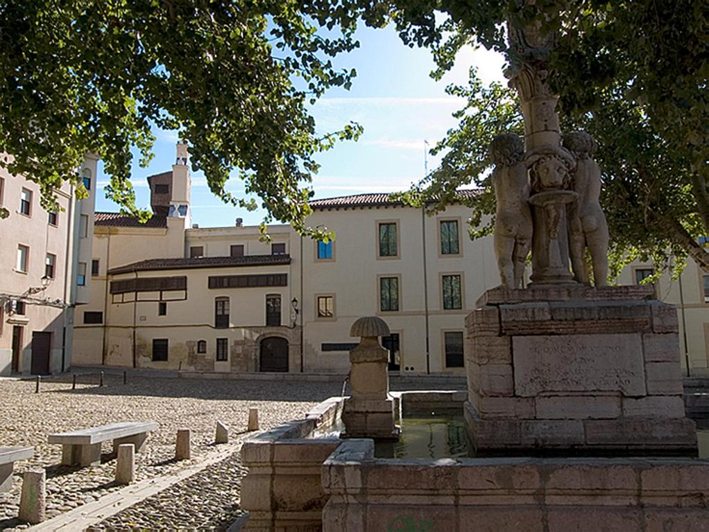 une fontaine au milieu d'une cour avec un bâtiment dans l'établissement Hospedería Pax, à León