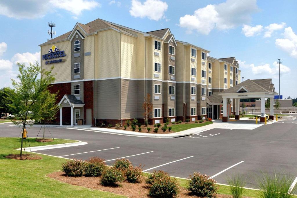 a rendering of a hotel with a parking lot at Microtel Inn & Suites by Wyndham Columbus Near Fort Moore in Columbus