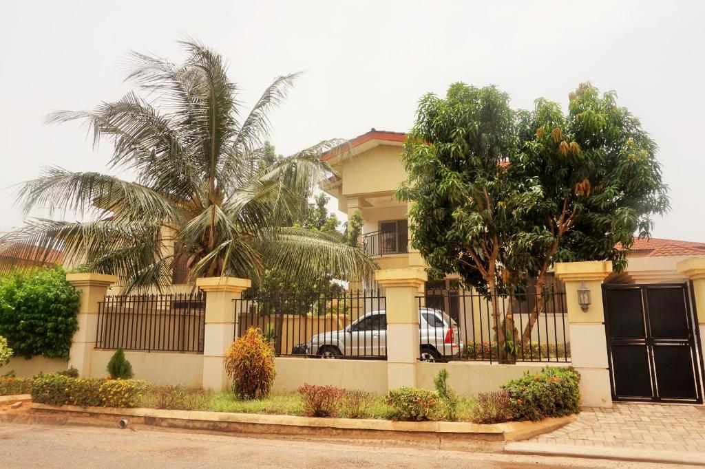 un coche aparcado frente a una casa con una valla en Sandpark Place, West Hills, en Accra