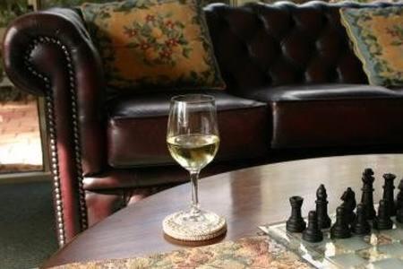a wine glass sitting on top of a couch next to a bottle of wine at Grandhouse York Guesthouse in York