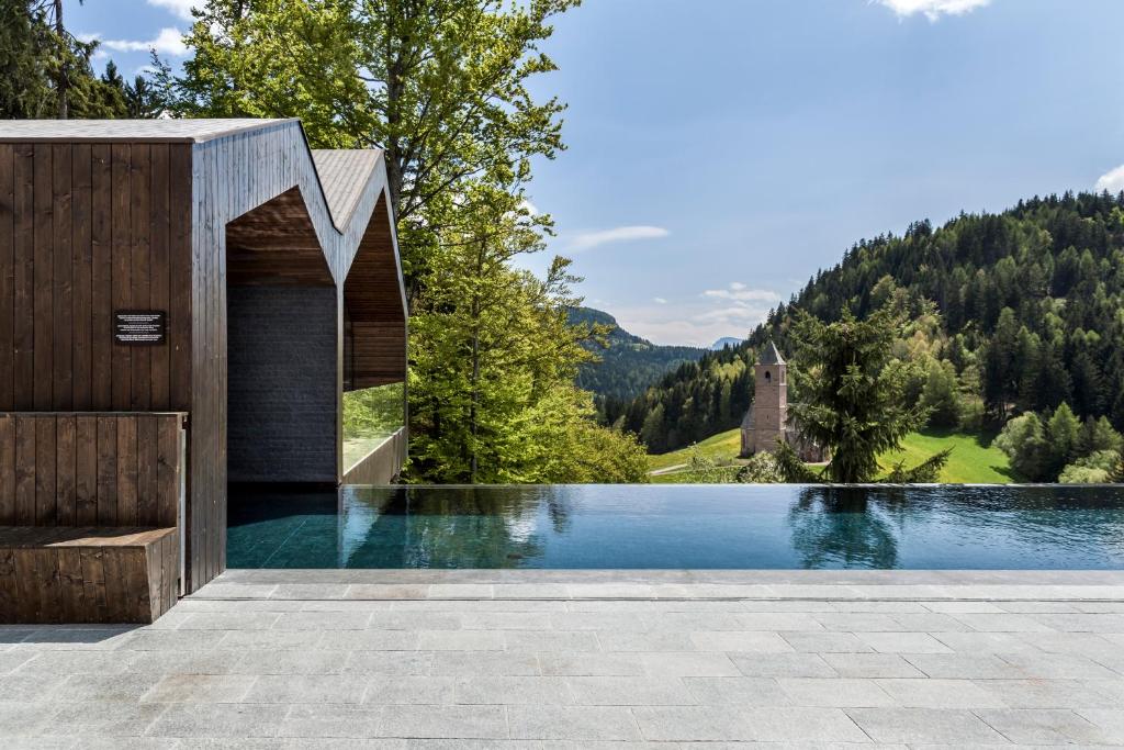 a house with a swimming pool in the mountains at Miramonti Boutique Hotel in Avelengo