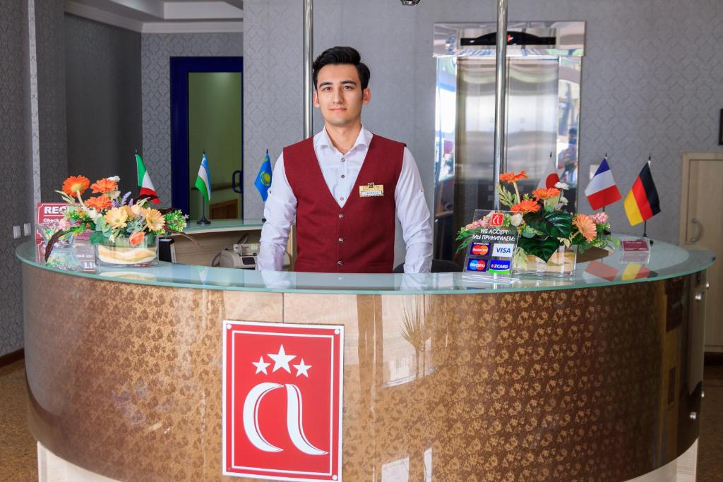 a man standing behind a counter in a room at City Line Boutique Hotel in Tashkent