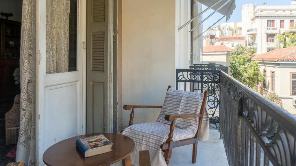 einen Balkon mit einem Stuhl und einem Tisch auf dem Balkon in der Unterkunft Plaka Vintage in Athen