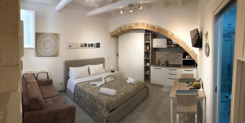 シラクーサにあるAppartamento Ortigiaのベッドルーム1室(ベッド1台付)、リビングルームが備わります。