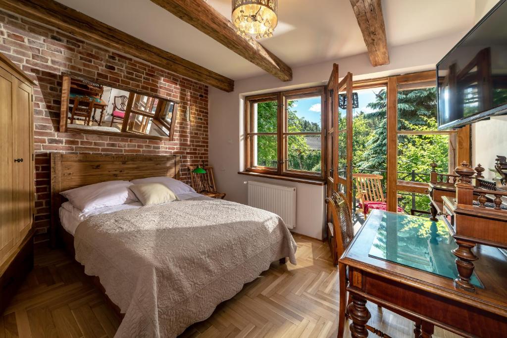 a bedroom with a bed and a brick wall at Apartamenty Dom Niezwykly in Karwia