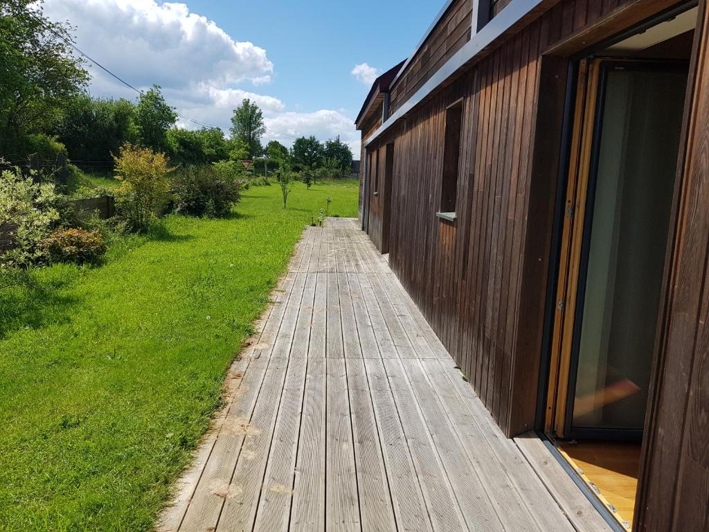 una pasarela de madera junto a un edificio en un campo en Le ptit Venton maison écologique pour particulier ou professionnel, en La Jaille-Yvon