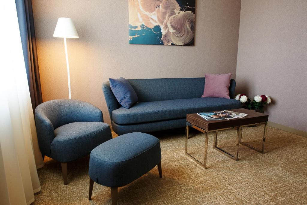 a living room with a blue couch and a table at Марциаль in Tyumen