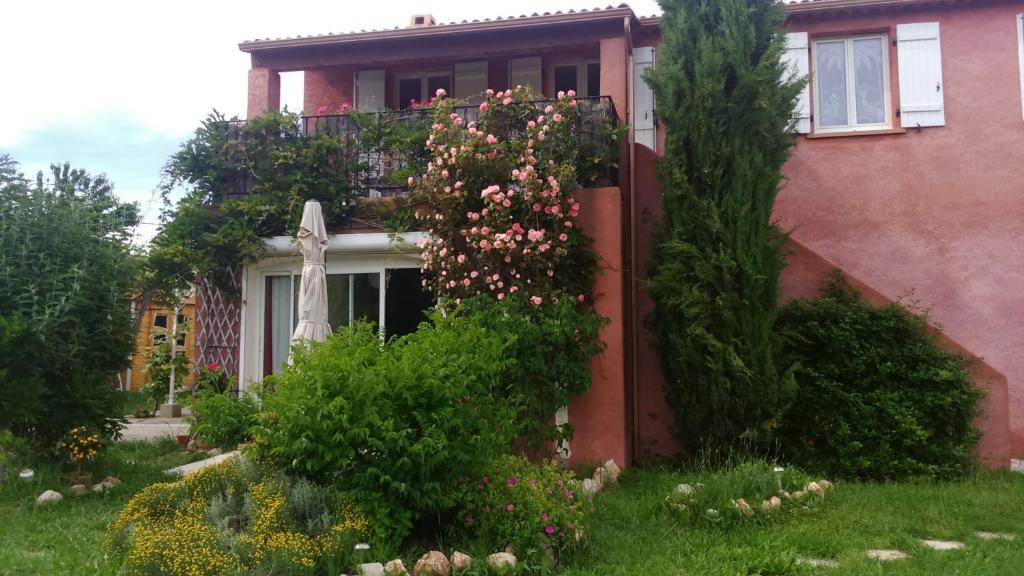 une maison avec une brousse de fleurs devant elle dans l'établissement Bio verdon, à Régusse