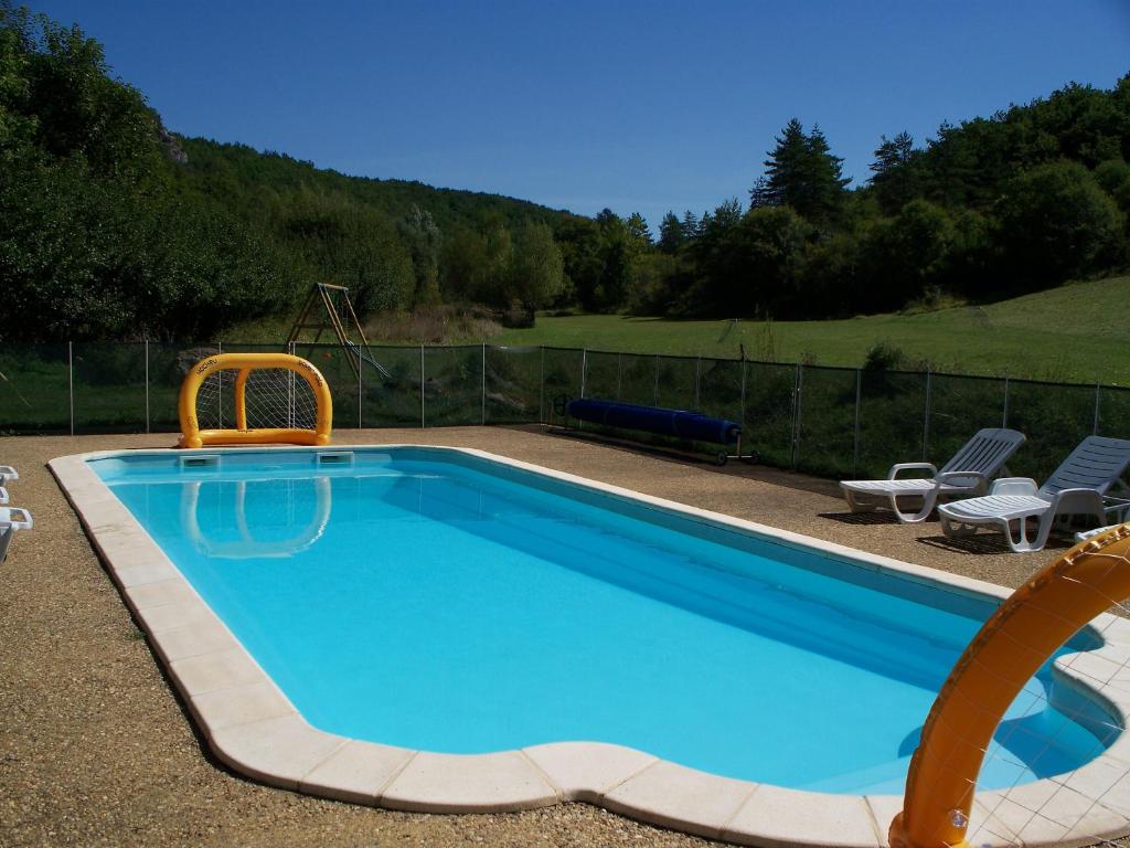 a swimming pool with two chairs and a slide at Les Gites Accromagnon, Climatisation in Les Eyzies-de-Tayac