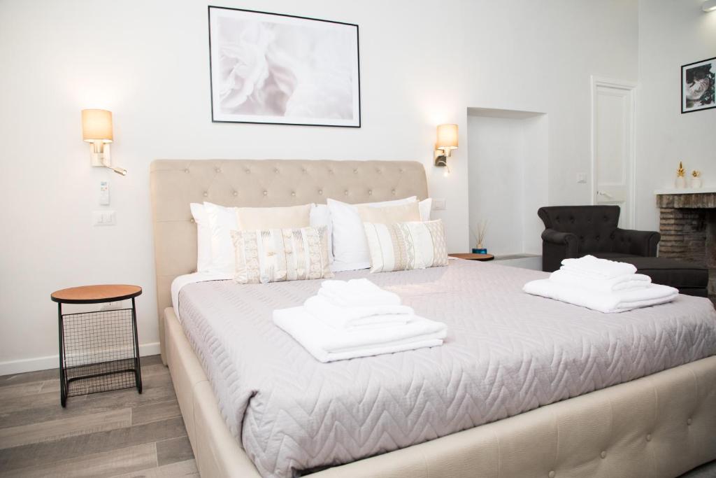 SuityRHome RioneMonti16 في روما: غرفة نوم عليها سرير وفوط بيضاء