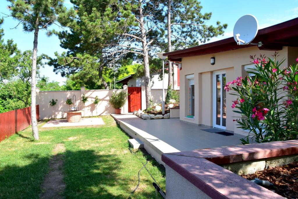 een klein huis met een patio en een tuin bij Kenese Panoráma Apartman in Balatonkenese