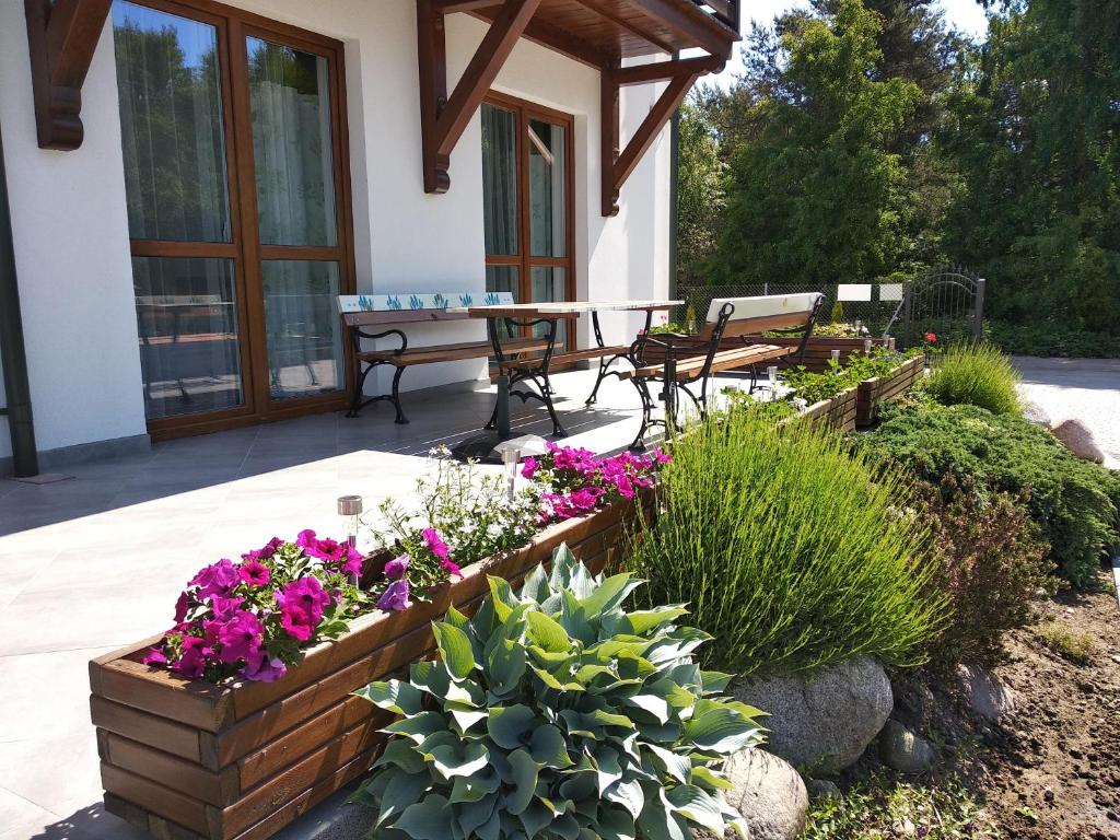 une terrasse avec une table, des bancs et des fleurs dans l'établissement Lawendowa Willa, à Władysławowo