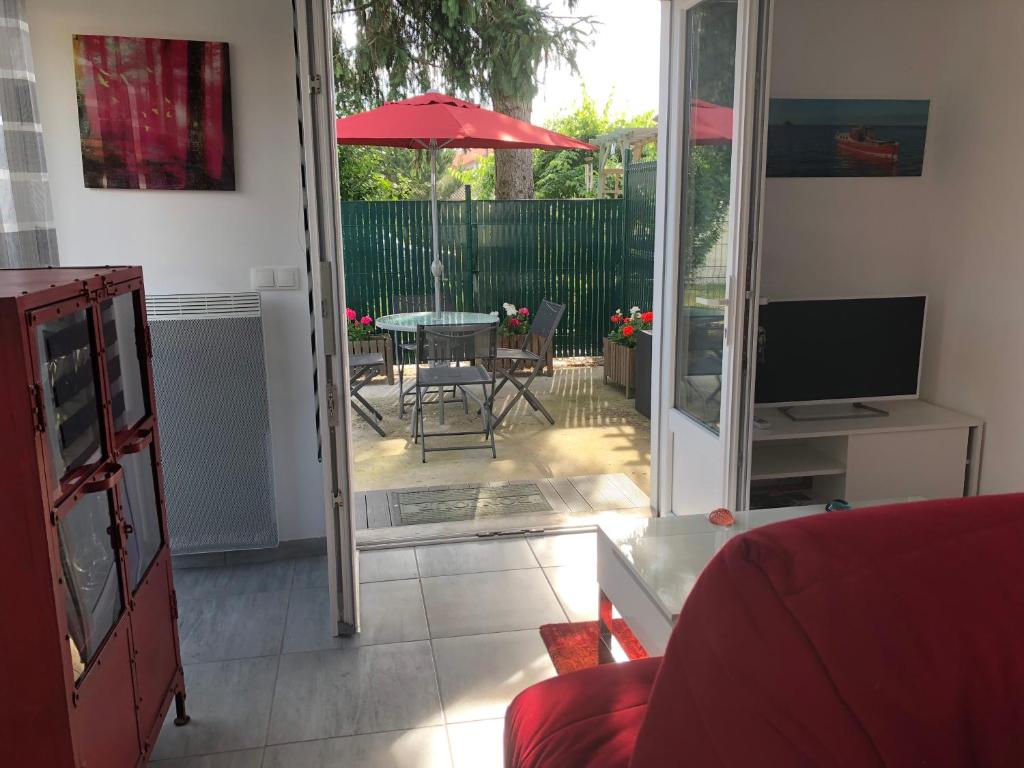 a living room with a patio with a table and an umbrella at Altéa in Pessac