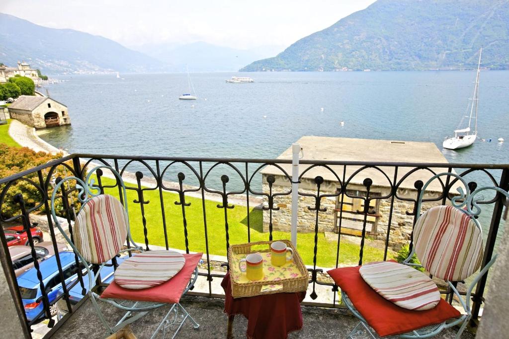 two chairs and a table on a balcony overlooking a body of water at Appartamento Lotte in Cannobio
