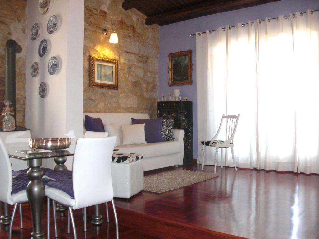 Sguardo Sul Barocco في راغوزا: غرفة معيشة مع أريكة بيضاء وكراسي