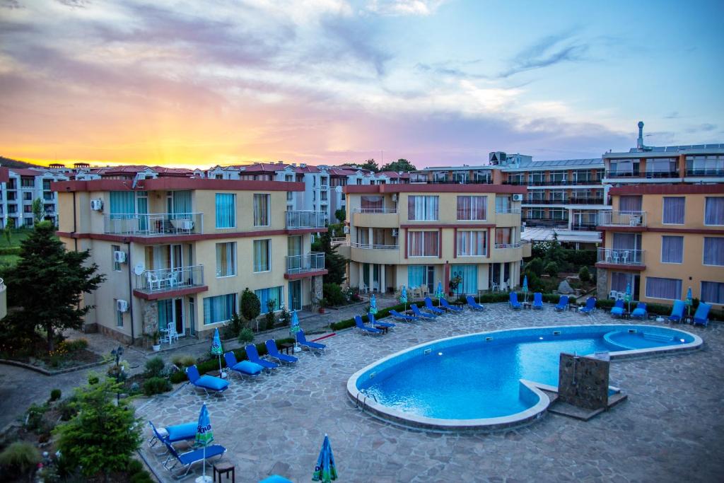 a view of a swimming pool with chairs and buildings at Mappy Holidays Aparthotel in Sozopol