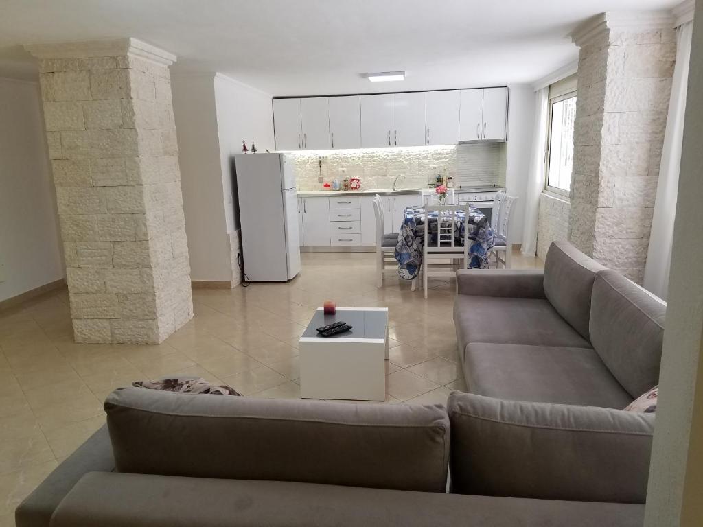 sala de estar con sofá, mesa y cocina en Luxury duplex Armand Durres, en Golem