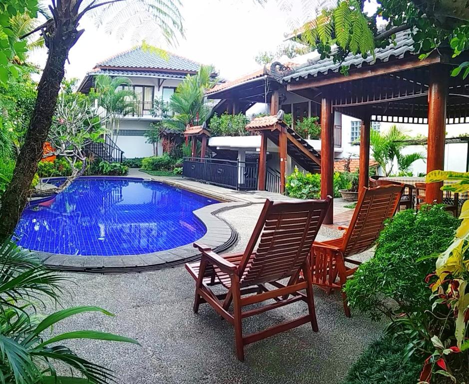 a patio with two chairs and a swimming pool at Jos & Hanny Homestay in Batu